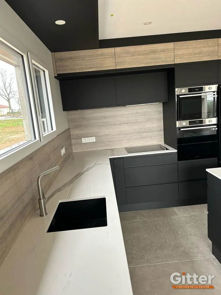 Cuisine en L, façades anthracite, plan de travail clair et crédence effet bois, réalisation Gitter à Richemont