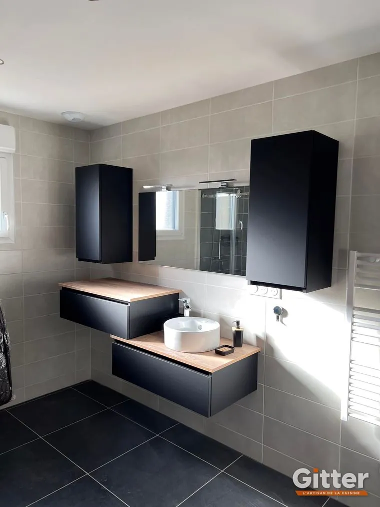 Salle de bains : meuble suspendu noir, vasque à poser, colonnes et sèche-serviettes, réalisation Gitter à Pompey