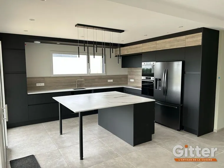 Cuisine : façades noires mates, îlot table, crédence bois et colonnes noires, réalisation Gitter à Custines