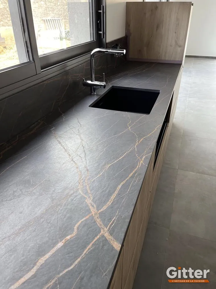 Cuisine : plan de travail effet marbre noir et or, évier noir et façades bois, réalisation Gitter à Hettange-Grande