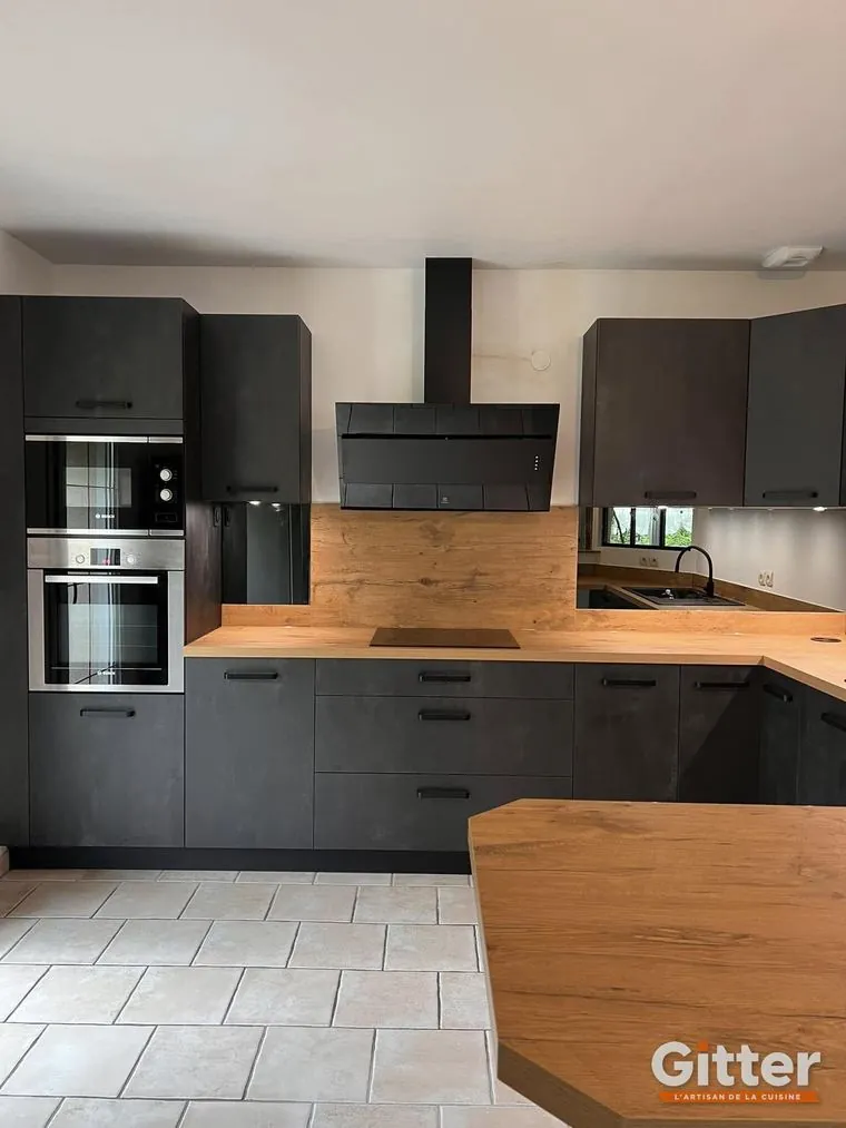 Cuisine : façades effet béton, plan de travail bois et hotte cheminée noire, réalisation Gitter à Amnéville