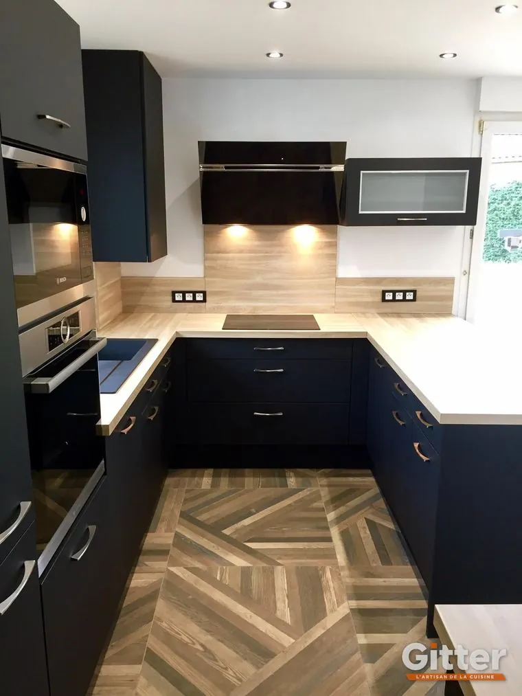 Cuisine en U, façades bleu nuit et plan de travail bois, parquet posé en chevrons, réalisation Gitter à Metz