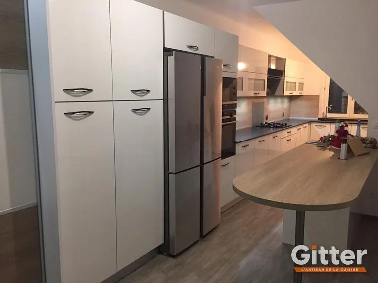 Cuisine : colonnes blanches, réfrigérateur américain et plan snack bois arrondi, réalisation Gitter à Augny