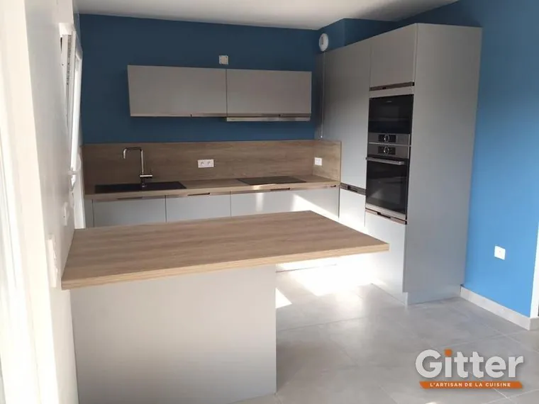Cuisine en U avec plan snack bois sur mur bleu, réalisation Gitter à Le Ban-Saint-Martin