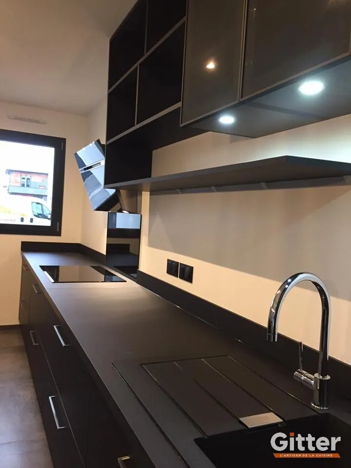 Cuisine : façades noires brillantes, plan de travail foncé, réalisation Gitter à Moyeuvre-Grande