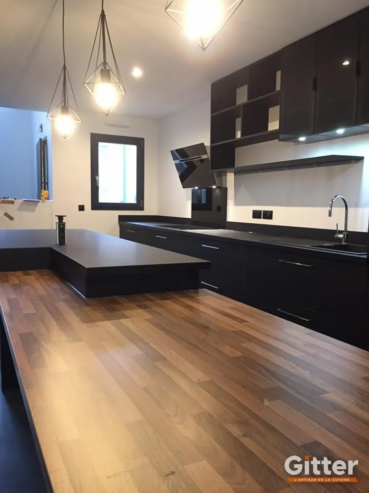 Cuisine : façades noires et plan de travail bois clair sur parquet, réalisation Gitter à Bousse
