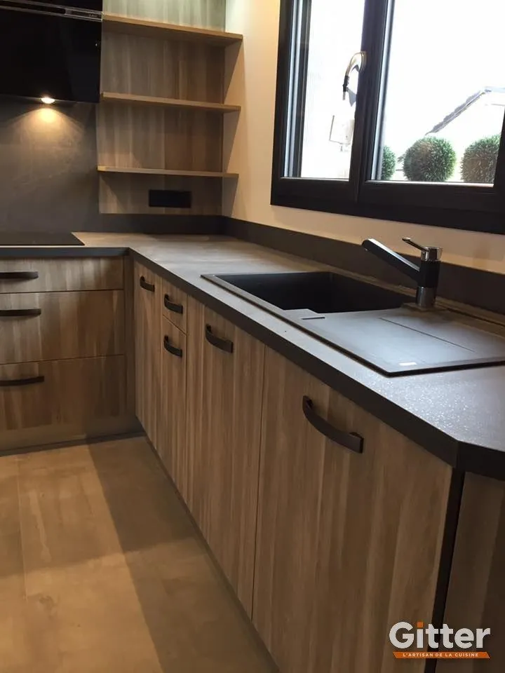 Cuisine : façades bois, plan de travail foncé et évier noir, réalisation Gitter à Maizières-lès-Metz