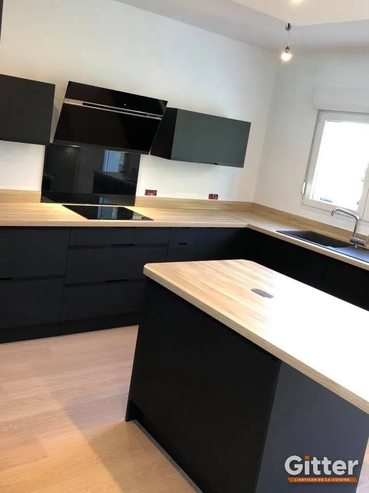 Îlot noir à plan de travail bois, façades noires sur parquet clair, réalisation Gitter à Clouange